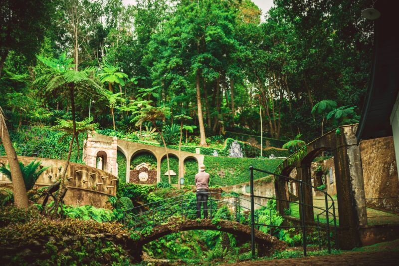 Monte Palace botanischer Garten in Madeira. Mann steht auf Brücke