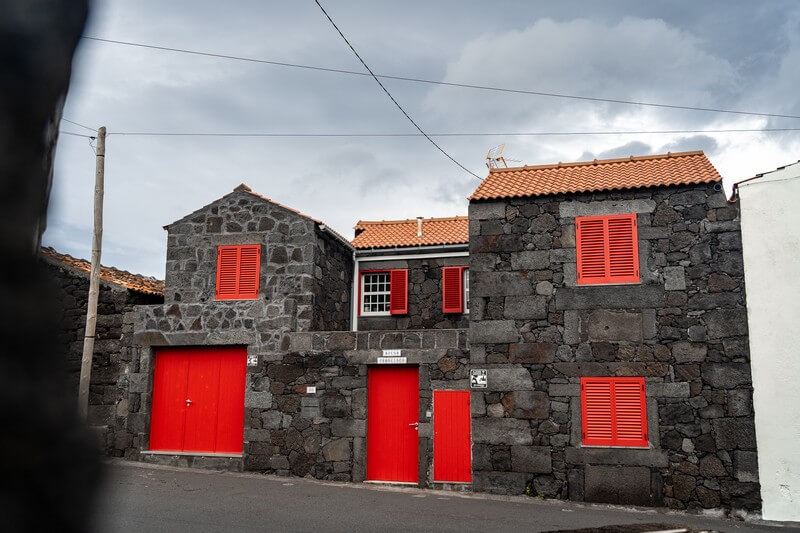 Vulkansteinhaus mit roten Fenstern in Arcos auf Pico