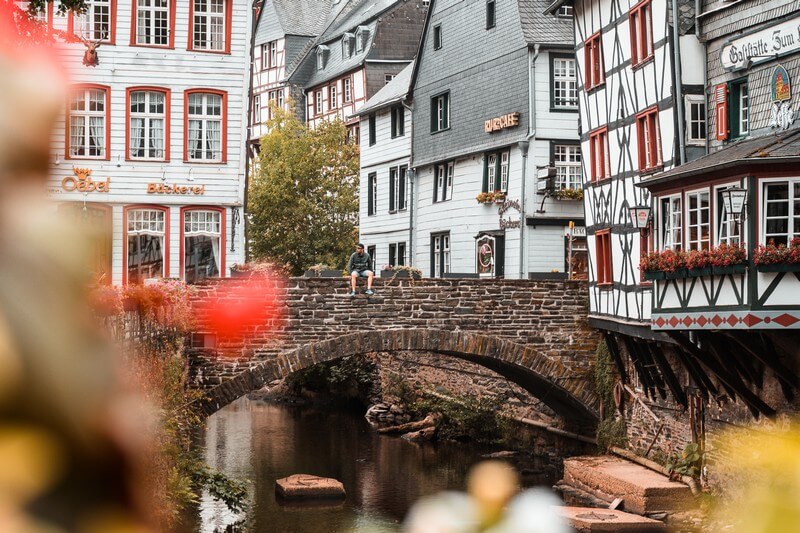 Brücke in Monschau auf der ein Tourist sitzt