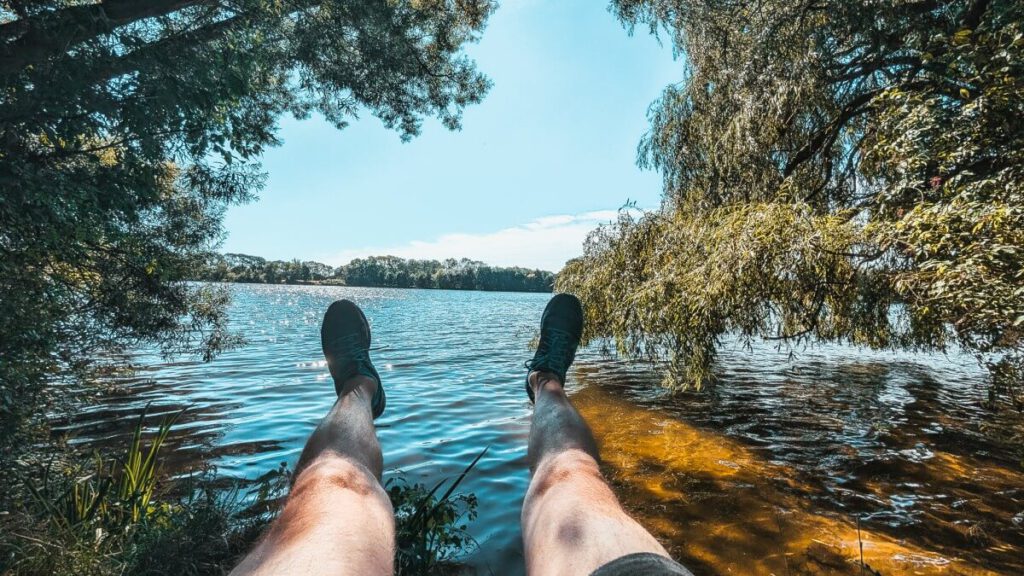 Mann hält Füße über das Wasser der Dove-Elbe