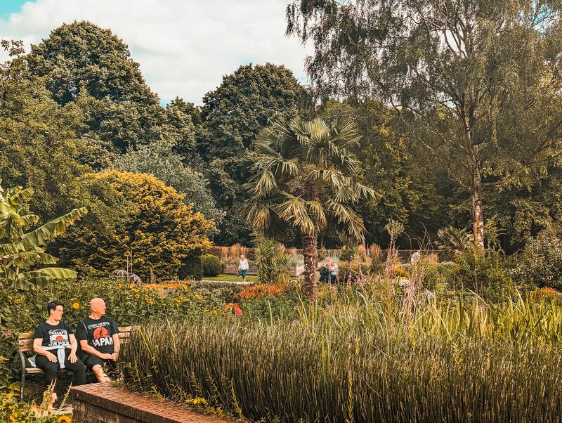 2 Besucher sitzen auf einer Bank im botanischen Sondergarten, einen der Hamburg Geheimtipps