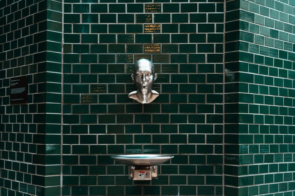 Wasserspeier vor grünen Ziegeln in den Hamburger Stadthöfen 