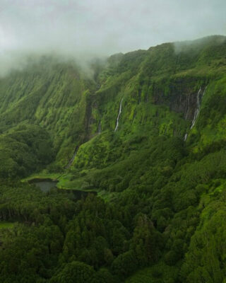 Eine Wand aus Wasserfällen die von einem Schleier aus Nebel umgeben ist auf der Insel Flores auf den Azoren