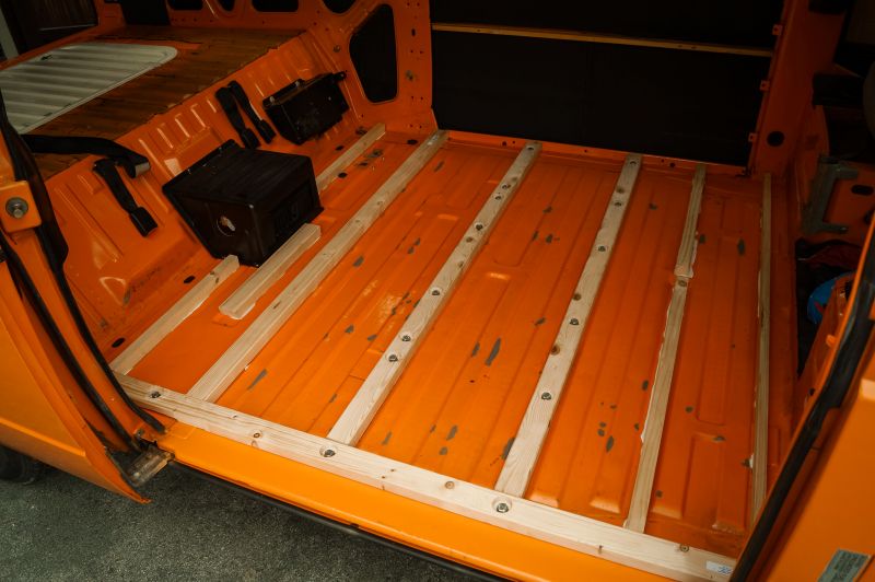 Wohnmobil Ausbau Boden Leisten auf Blech eines orangenen VW T3 Camper Vans