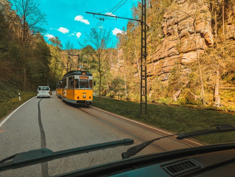 Die gelbe Kirnitzschtalbahn teilt sich die Straße mit den Autofahrern.