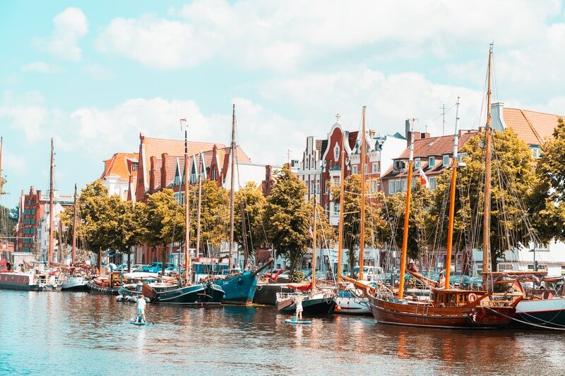 Old boats anchored in Lübeck's museum harbour, photographed from the opposite side.