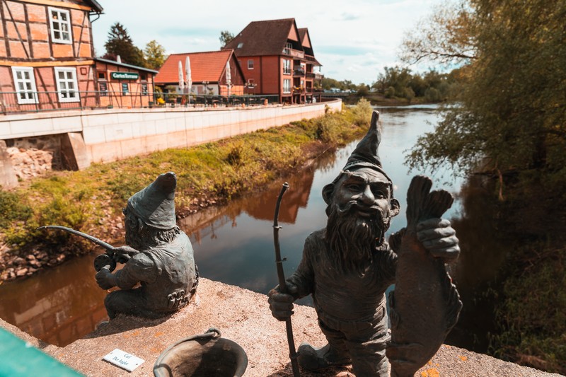 Zwei angelnde Zwergfiguren auf der Brücke in die Altstadt von Hitzacker.