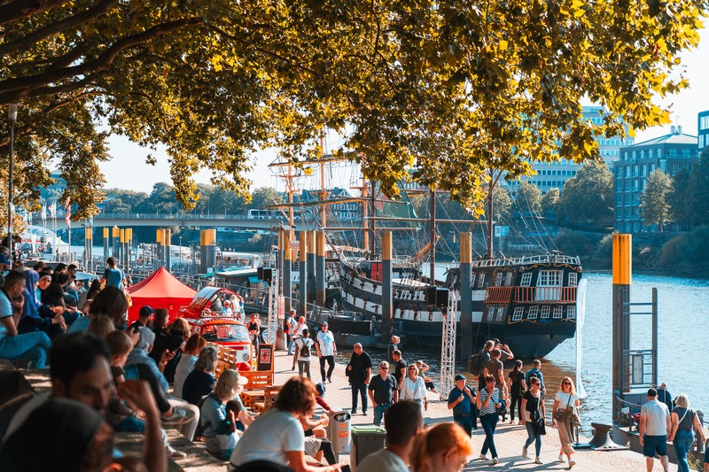 Menschen laufen entlang der Schlachte in Bremen, die maritime Flaniermeile an der Weser