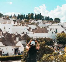 Eine Touristen freut sich über die vielen Alberobello Sehenswürdigkeiten und macht Fotos