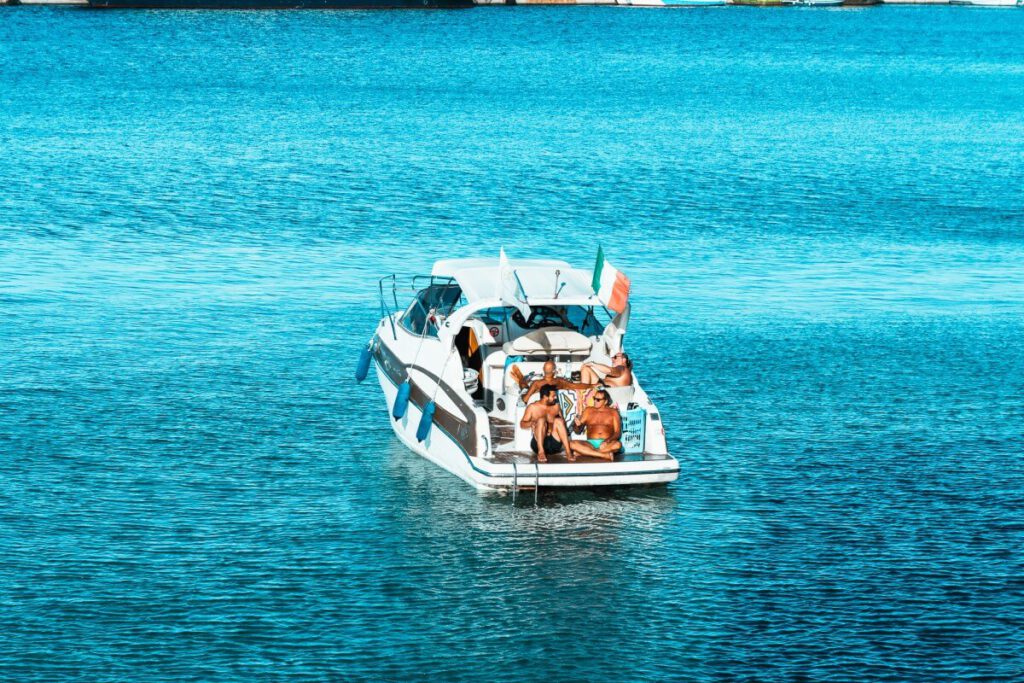 Männer sitzen auf einem Boot vor der Küste Otrantos.