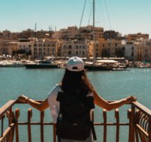 Eine Frau blicke auf den Hafen von Trani in Apulien.