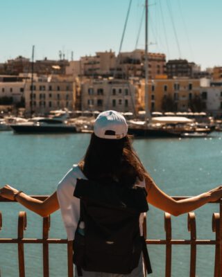 Eine Frau blicke auf den Hafen von Trani in Apulien.