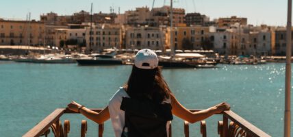 Eine Frau blicke auf den Hafen von Trani in Apulien.