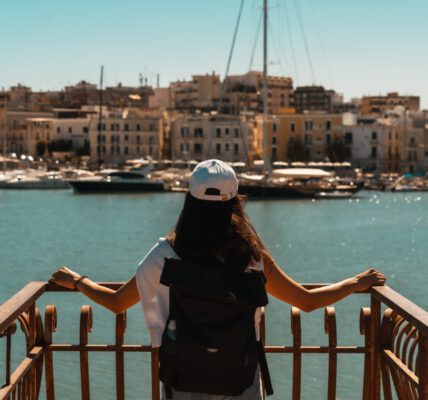 Eine Frau blicke auf den Hafen von Trani in Apulien.