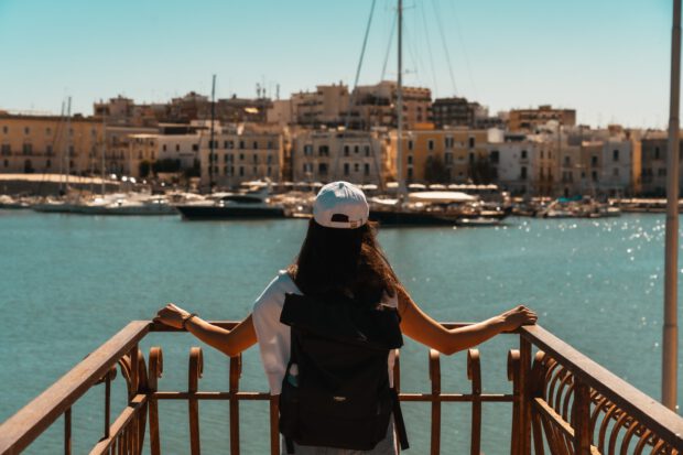 Eine Frau blicke auf den Hafen von Trani in Apulien.