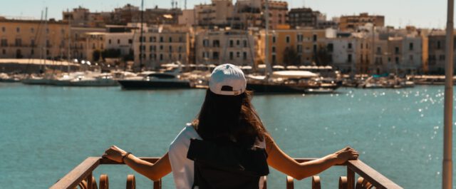 Eine Frau blicke auf den Hafen von Trani in Apulien.