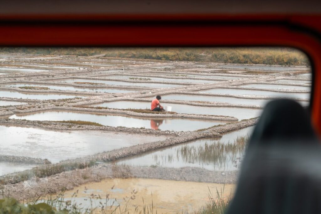Ein Arbeiter bearbeitet ein Salzbecken in Guerande