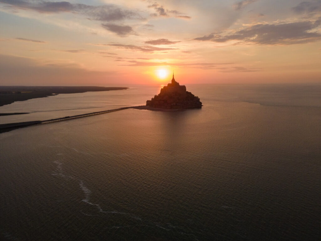 Mont Saint-Michel bei Flut zum Sonnenuntergang aus der Distanz