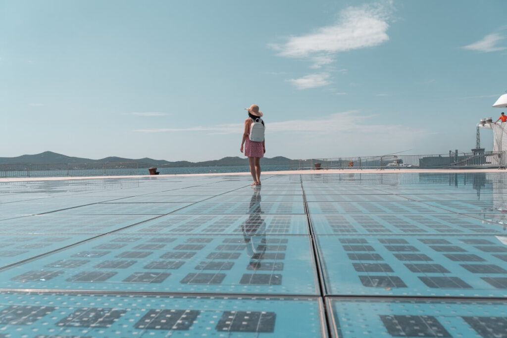 Frau steht auf dem Gruß an die Sonne Kunstwerk in Zadar