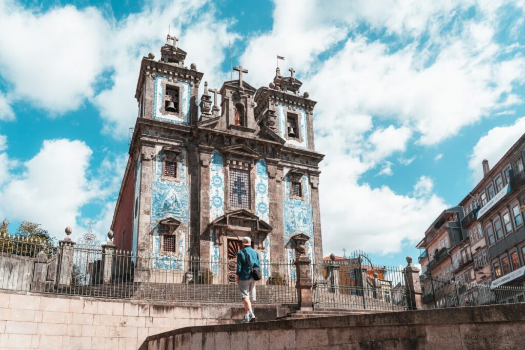 Ein Model läuft vor der Kirche Igreja de Santo Ildefonso in Porto