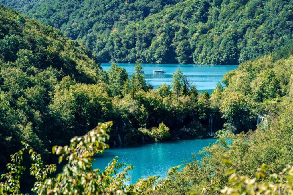 Ein Boot fährt auf dem größten See des Nationalpark Plitvicer Seen – dem Kozjak See