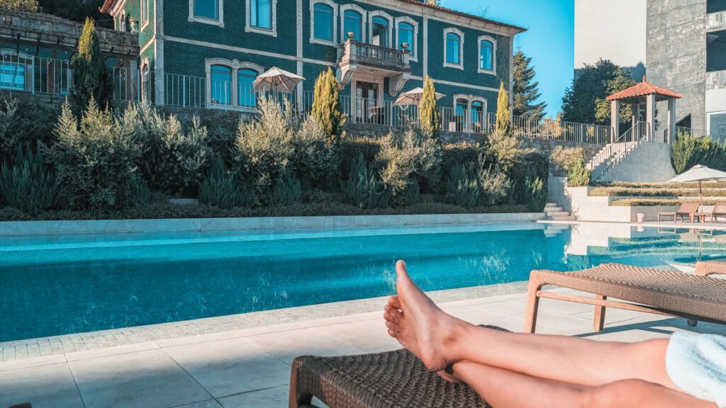 Füße auf einer Liege vorm Hotelpool