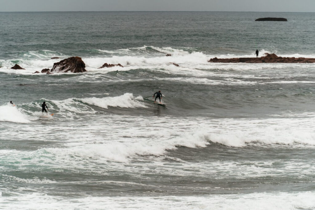 Surfer reiten die Wellen vor Biarritz