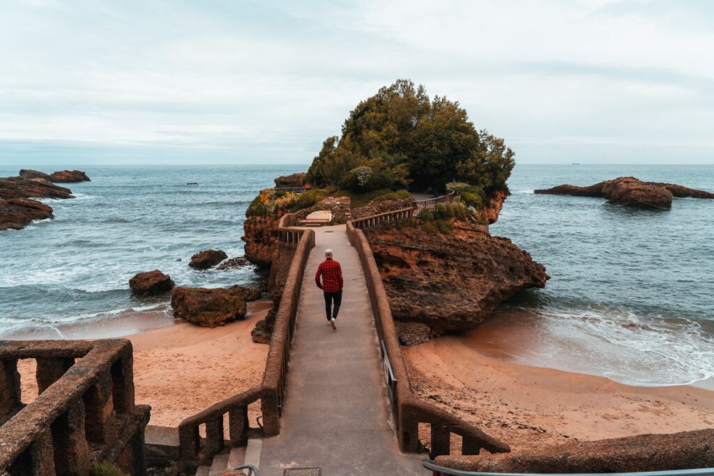 Mann läuft über Brücke auf den Rocher du Basta in Biarritz
