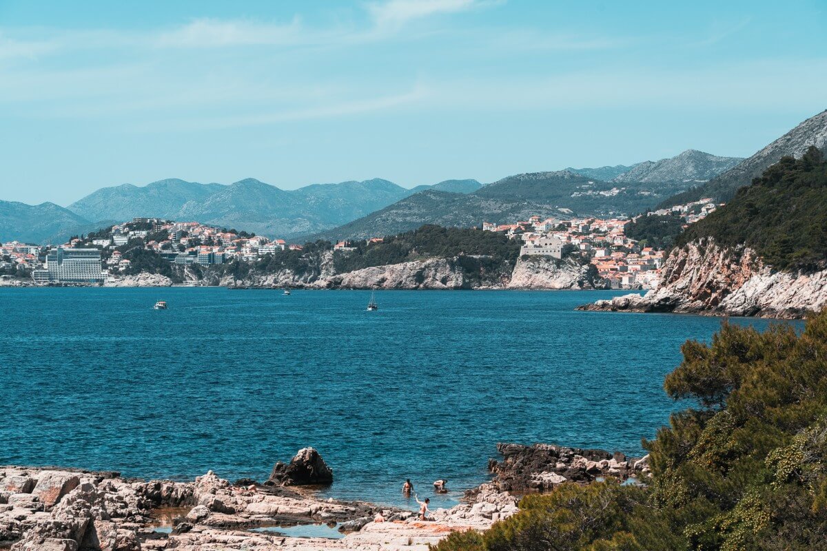 Gäste schwimmen an den Felsen im Süden der Insel Lokrum