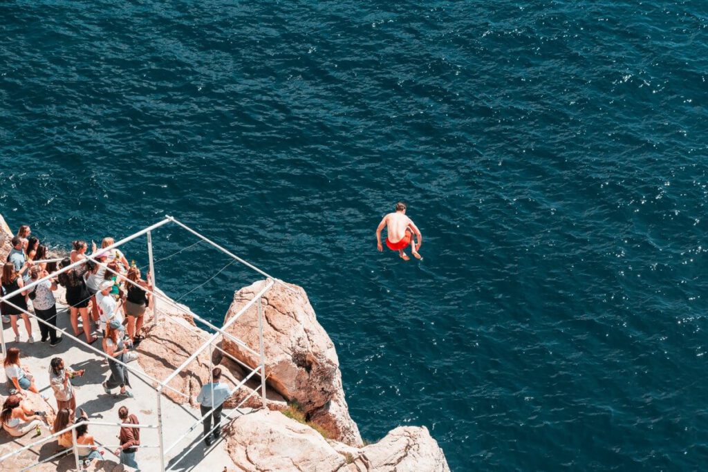Wagemutiger Klippenspringer stürzt sich bei der Buža Bar in die Tiefe