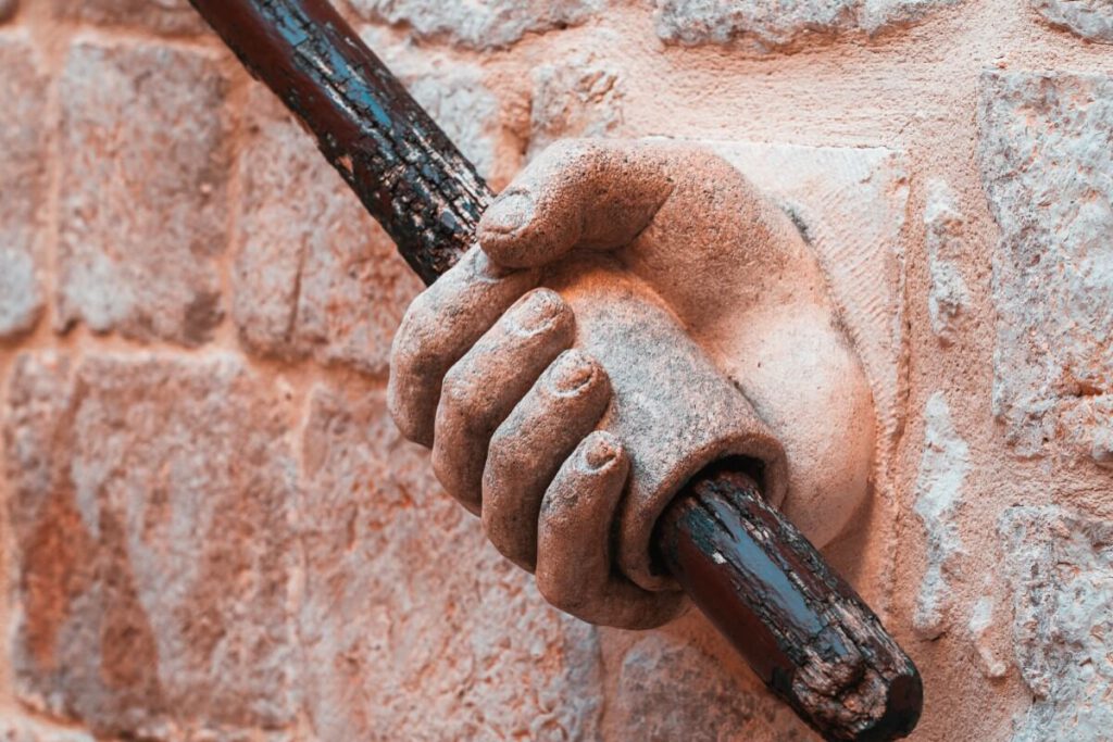 Stein-Ornament in Form einer Hand in die das Treppengeländer des Rektorenpalastes eingefasst ist