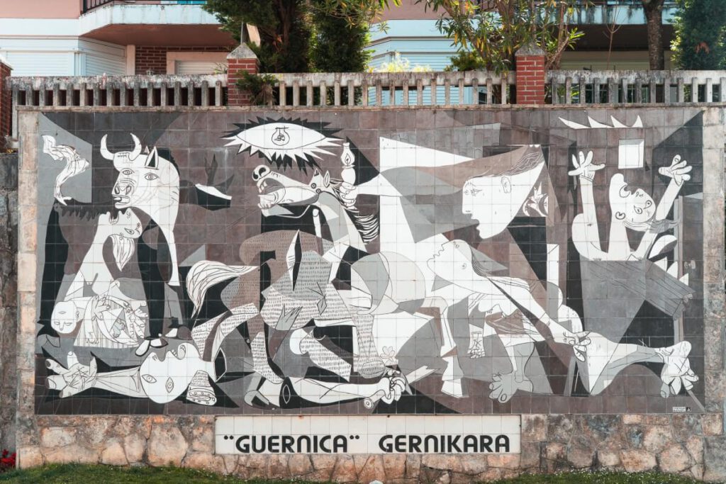eine Reproduktion von Picassos Guernica auf Keramikfliesen, in Originalgröße, an einer Wand nahe dem Versammlungshaus