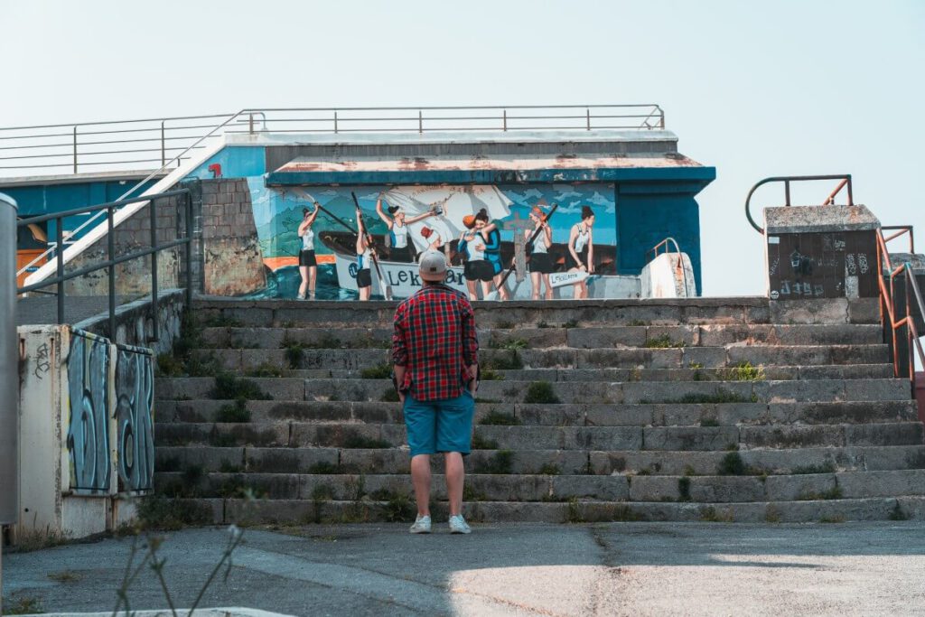 Mann steht vor einem Graffiti am Hafen von Lekeito