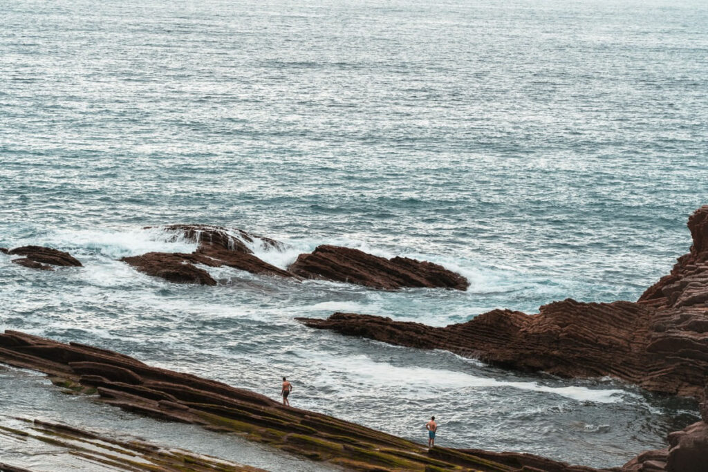 2 Badegäste stehen an den Flyschformationen in Zumaia