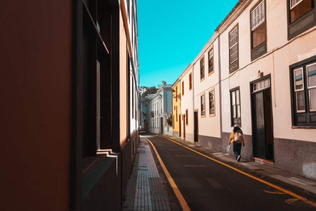 Frau läuft durch leere Gasse in der UNESCO Altstadt von La Laguna auf Teneriffa