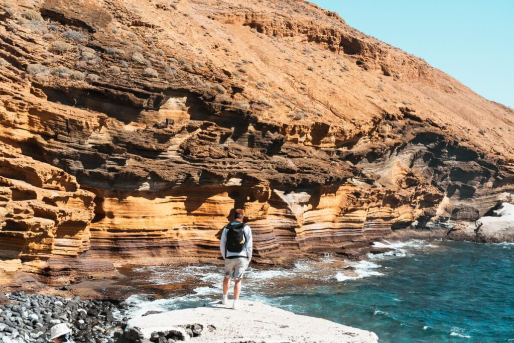 Mann steht an der Küste vor der Playa Amarilla