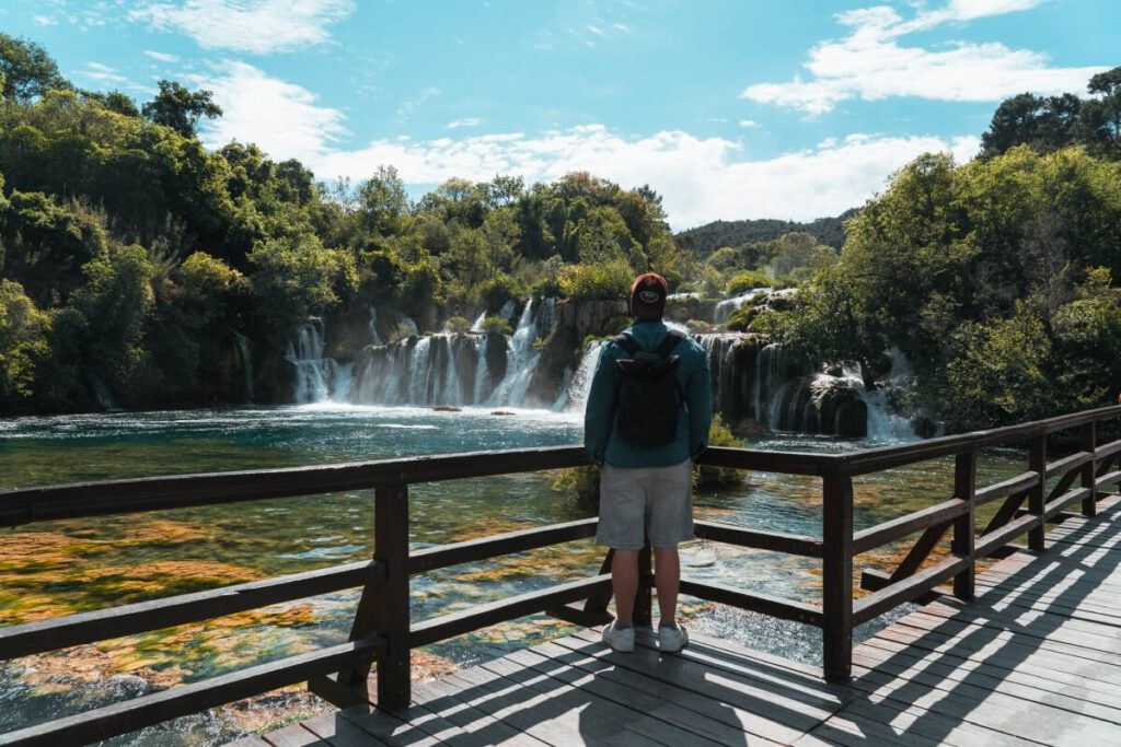 Mann steht an einer Wasserfall Kaskade am Skradinski Buk