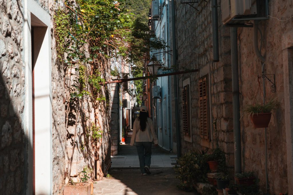 Frau läuft durch Gasse in Ston